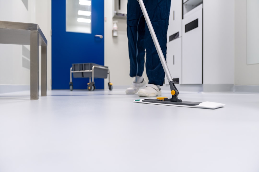 A cleaner is washing the floor in a laboratory setting